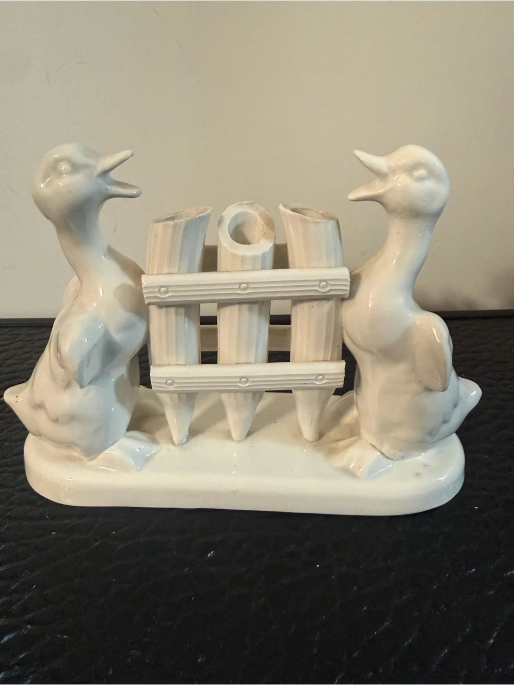 vintage ceramic toothbrush holder two ducks flanking a fence-like structure.